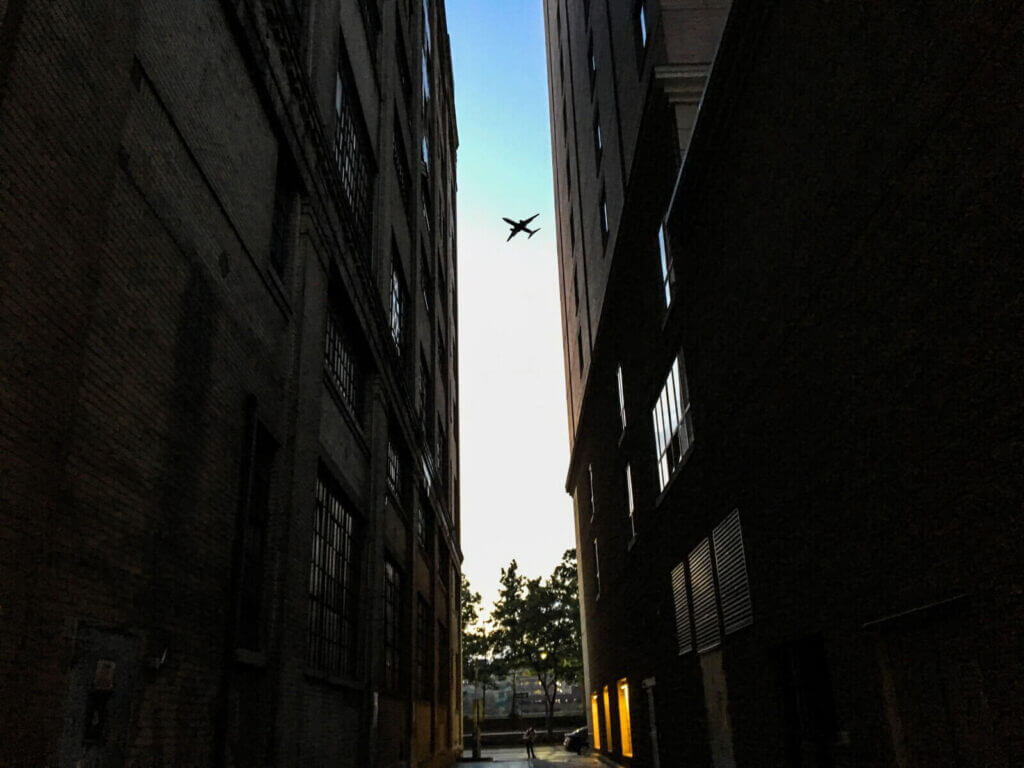 plane flying over buildings