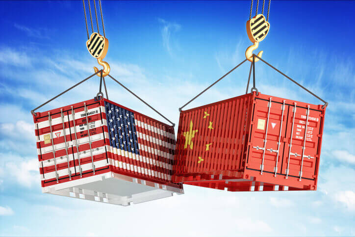 Trump to impose tariffs on Chinese imports 1 US and China flag-wrapped shipping containers clashing mid-air on crane hooks against a blue sky, illustrating US-China trade war and tariff tensions.