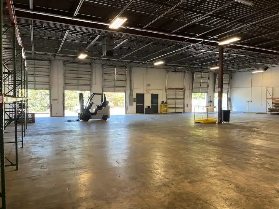 Jade International Expands Warehouse Operations 2 Spacious interior of Jade International's warehouse facility with multiple open loading dock doors, a forklift, and wide open floor space for container unloading, short-term storage, and freight consolidation.