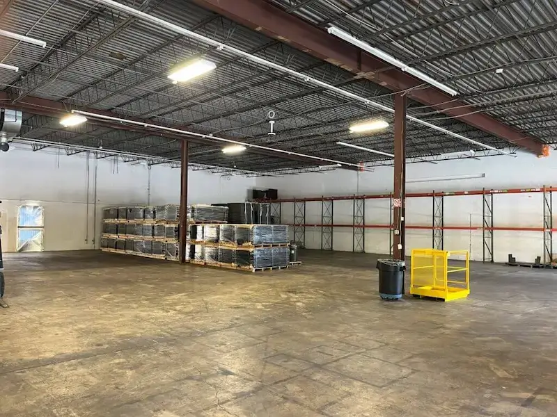 Jade International Expands Warehouse Operations 3 Jade International warehouse floor with stacked shrink-wrapped pallets, pallet racking along the wall, and open storage space, representing their container unloading, short-term storage, and export consolidation services.