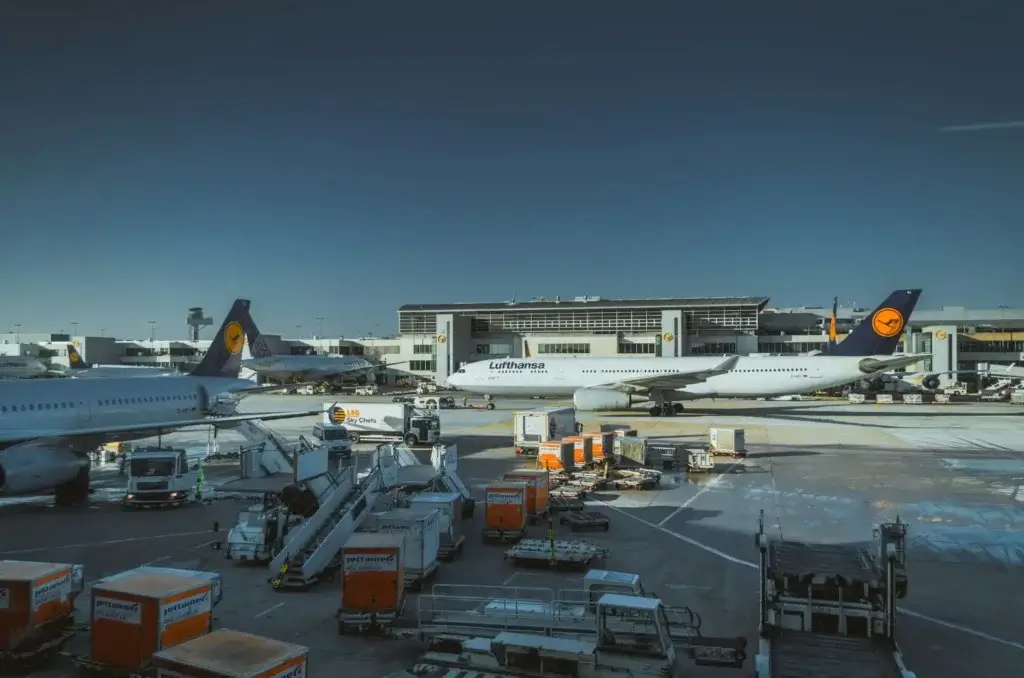 Air Export Solutions with Lufthansa aircraft at an international airport cargo apron, ground handling equipment, and freight containers ready for loading.