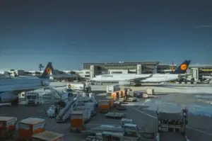 Air Export Solutions with Lufthansa aircraft at an international airport cargo apron, ground handling equipment, and freight containers ready for loading.