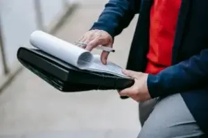 Professional reviewing ocean export documentation and shipping papers in a leather portfolio