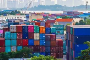Stacked colorful shipping containers at a port yard, illustrating demurrage and detention fees from delayed cargo pickup.