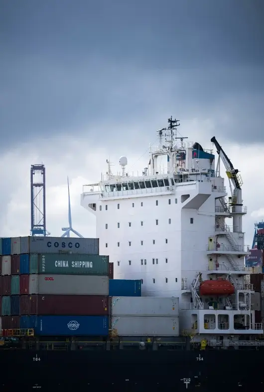 Large cargo ship stacked with COSCO and China Shipping containers, representing oversized freight transportation logistics