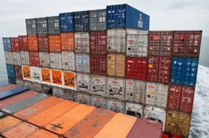 Stacked shipping containers aboard a cargo vessel crossing open sea